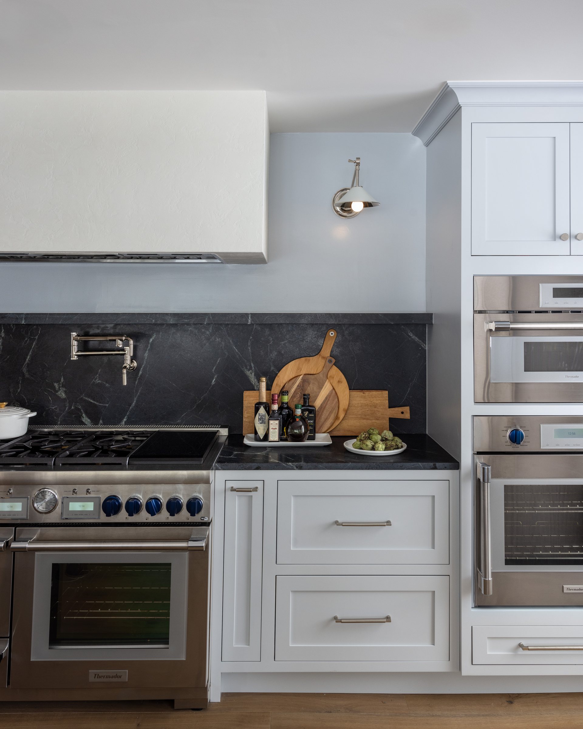 Range with a blue-tile backsplash and custom hood, built by Mosher Dolan