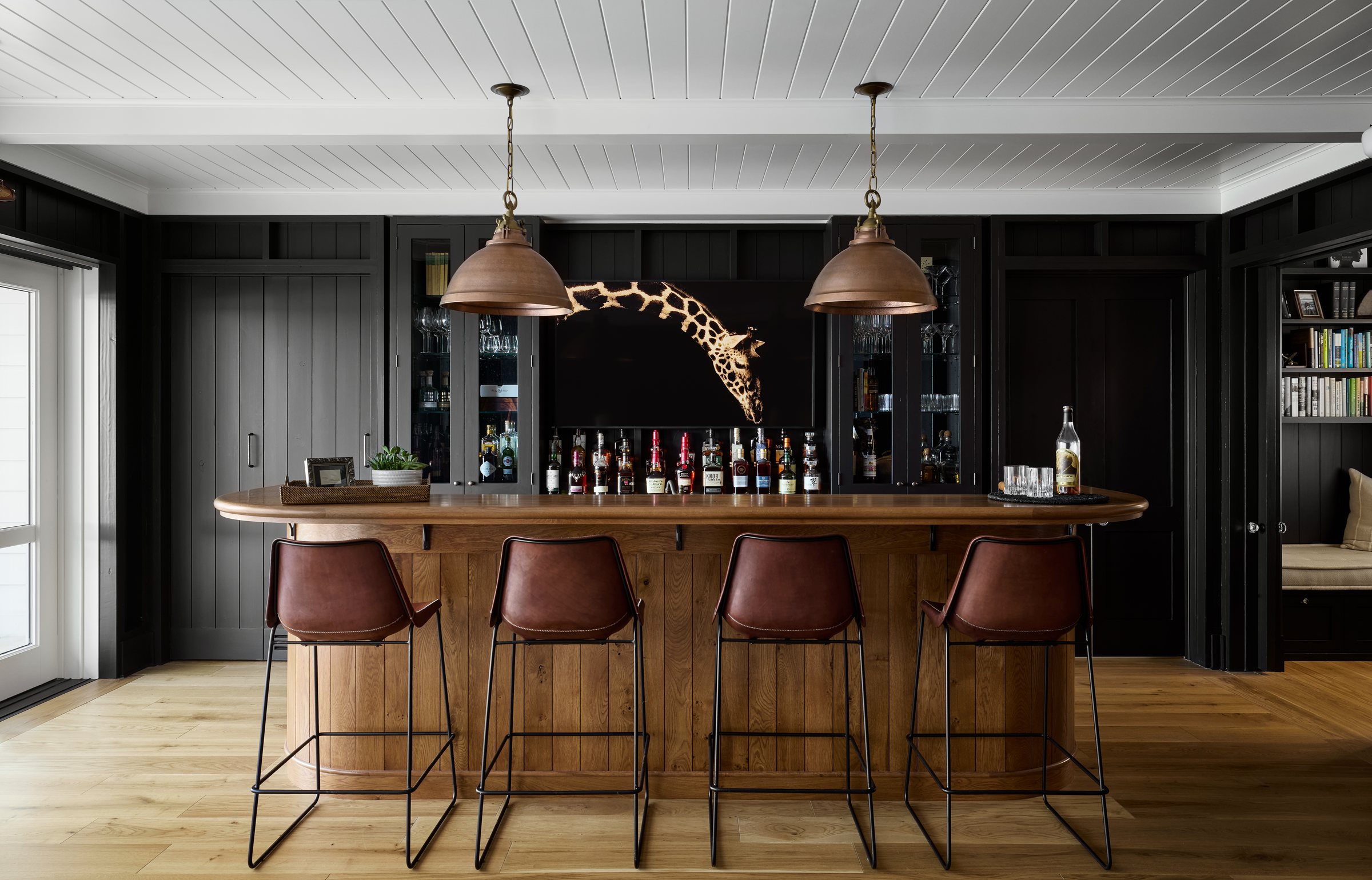 Wet bar with dark cabinetry and open shelving
