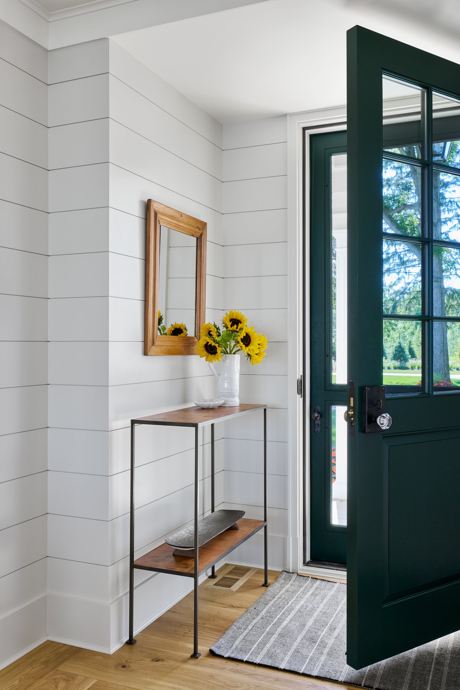 Entry with a green Dutch door and shiplap walls