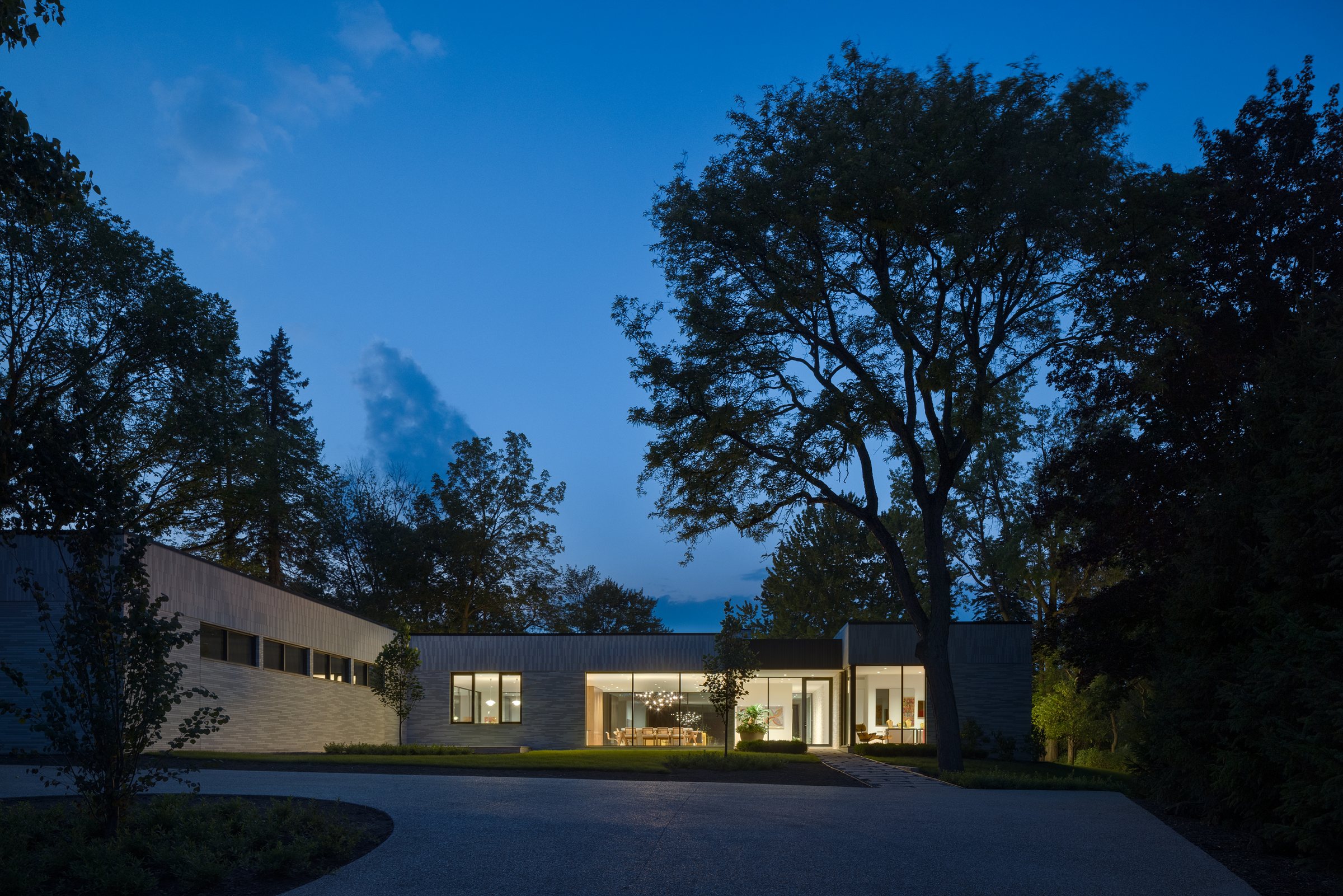 The house at dusk, lit from within