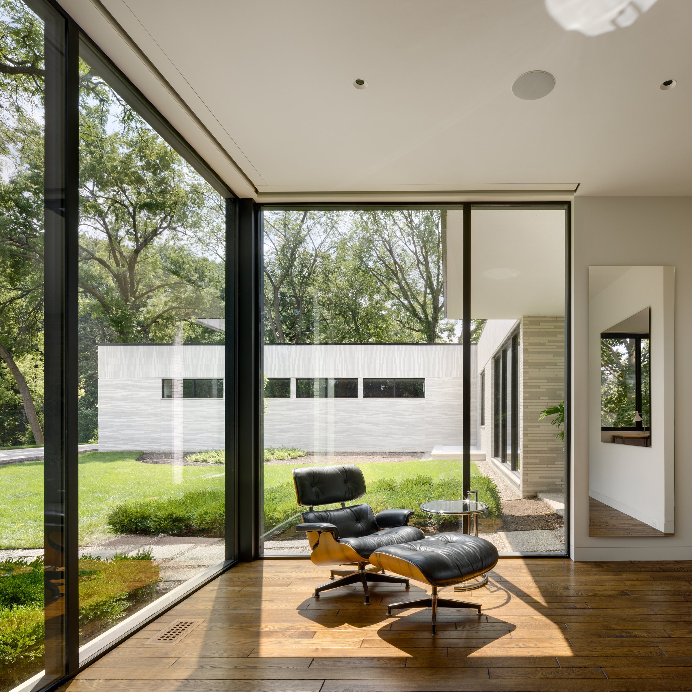 Corner of glass with a lounge chair looking across the courtyard