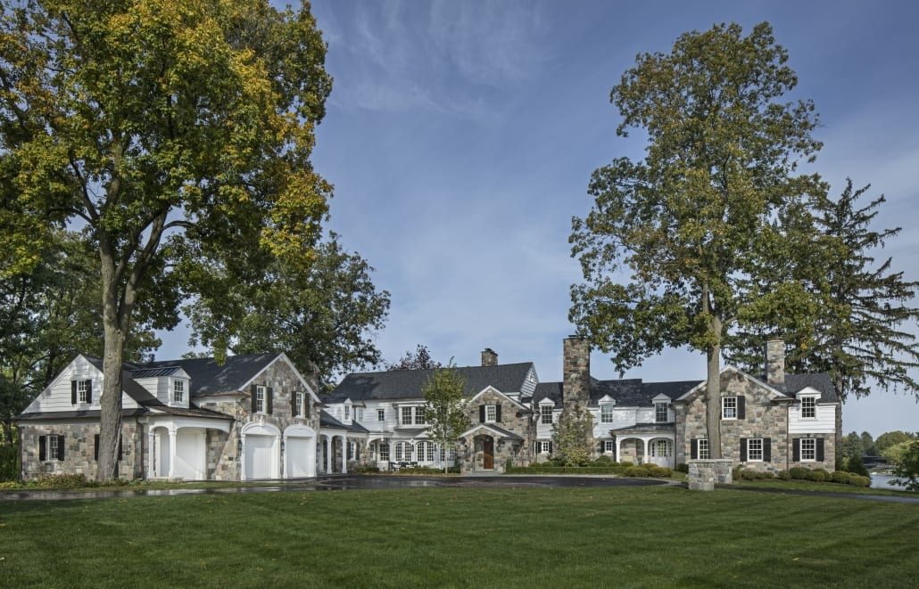 Front elevation of the Historic Lake Retreat: a long stone house under old trees, original and addition reading as one