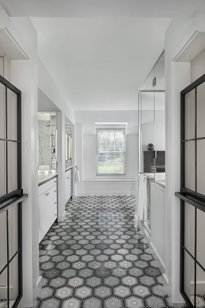Bath with a patterned tile floor and steel-framed glass
